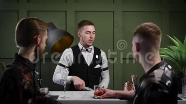 一个男<strong>调酒师</strong>准备鸡尾酒。 游客的两个朋友正在<strong>酒吧</strong>等他们的饮料。